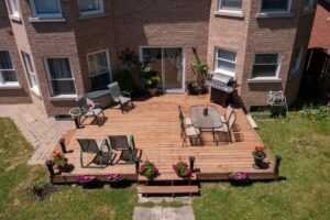 a custom wooden deck with patio furniture and steps leading to the backyard
